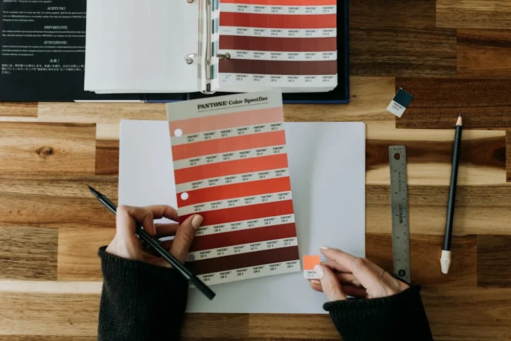 Designer comparing colour swatches on a wooden desk